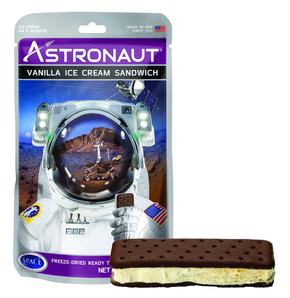A 5" x 6" package with a close-up of an Astronaut in a white spacesuit holding a freeze-dried ice cream sandwich. Space Rover is reflected in the face shield of the helmet. A freeze-dried vanilla ice cream sandwich is sitting in front of the package.