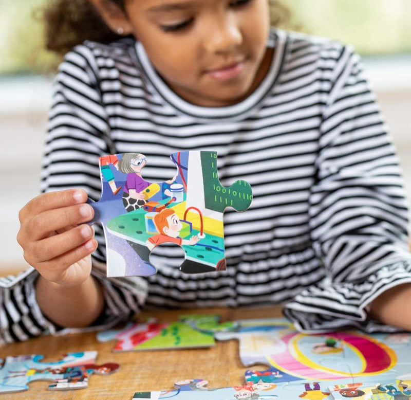 A young smiling child is putting the puzzle together on a table. She holds one of the large pieces toward the viewer to show the size of the pieces.