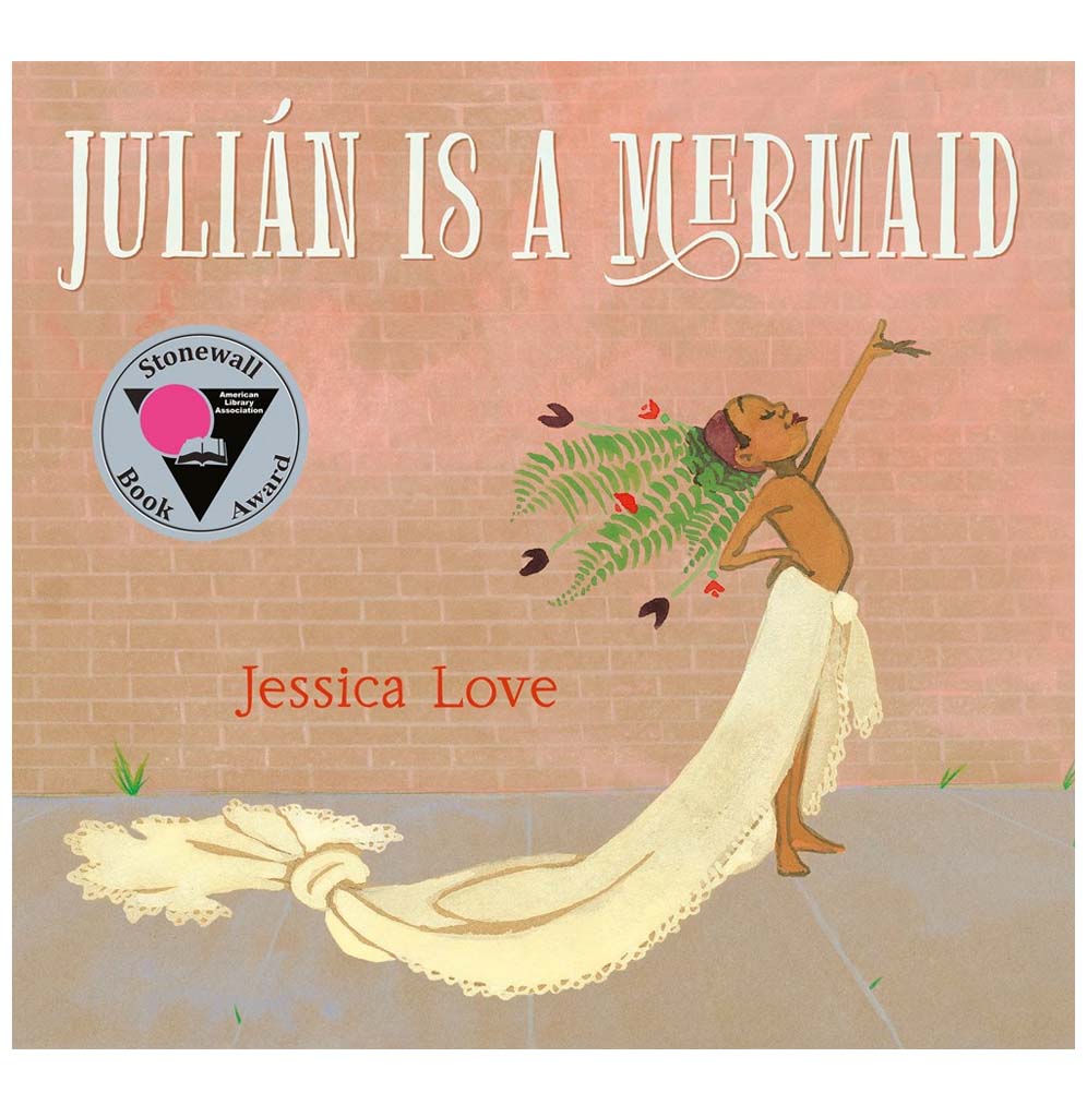 A hardcover book with a pinky beige cover illustrates a young boy wrapped in a yellow blanket from the waist down and fern fawns in his hair.