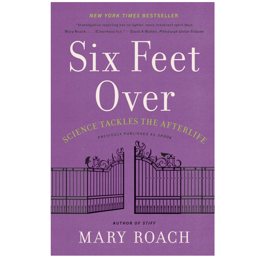 "Six Feet Over" is a paperback book with a purple cover; an elaborate black gate is on the cover, similar to what one would find leading to a graveyard.