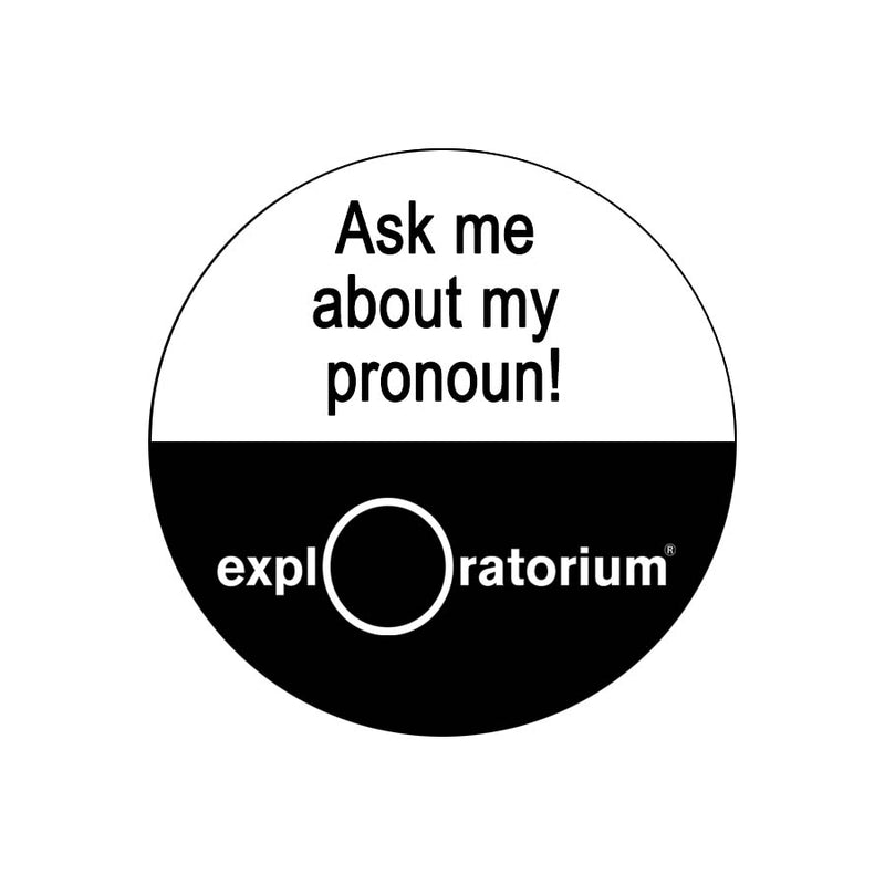Ask me about my pronoun! pin in all caps in black text against a white background on the top half of the pin. Exploratorium in white text against a black background.