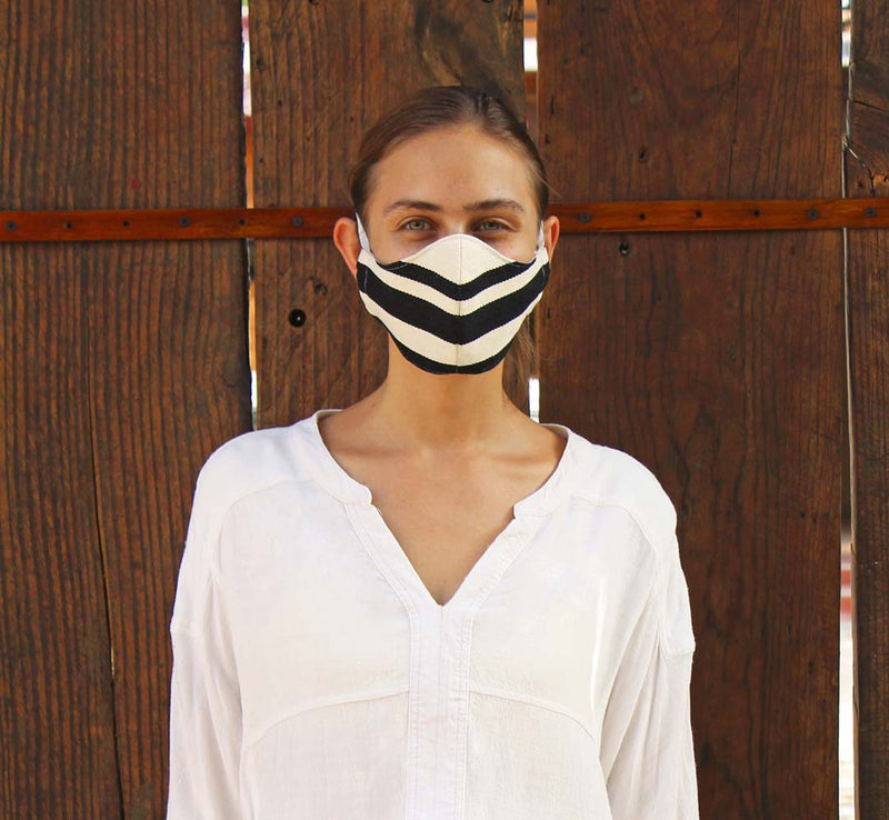 Female wearing black and white striped COVID-19 mask