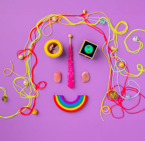 A collection of toys and string that forms the shape of a smiling face.