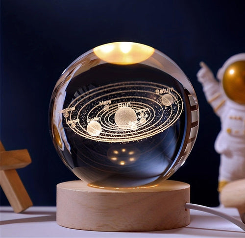 A acrylic sphere with the solar system depicted inside sitting on a table. 