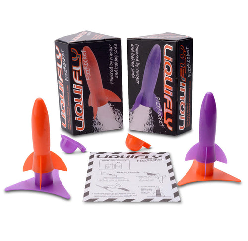 Purple and orange plastic rockets are displayed with instructions sheet between them and two black boxes behind them. 