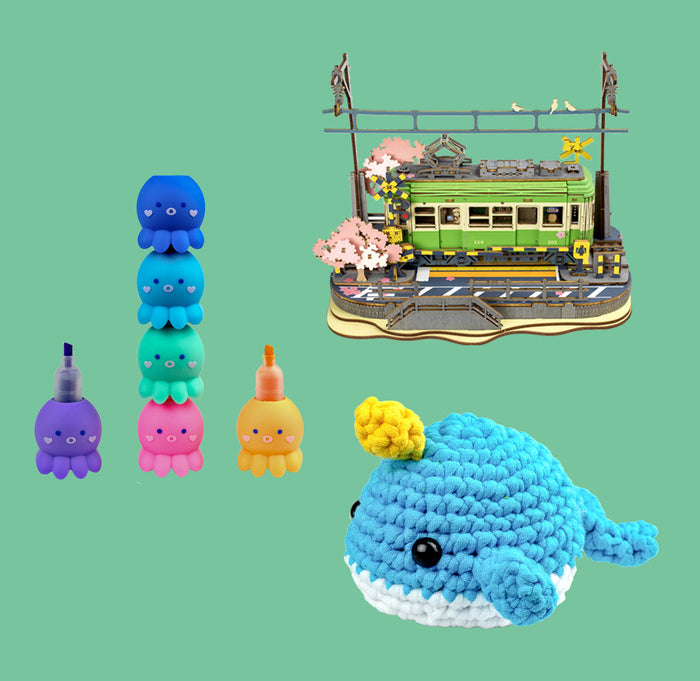 Octopus markers, a train, and a crochet narwhal are on a green background