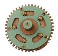Wooden gear mechanism with a green circular plate, toothed rim, brass screws, curved cutouts, and a raised central hub on white.