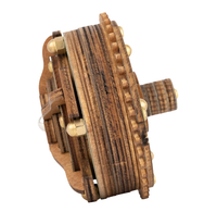 Close-up of an antique wooden spool or reel with layered grain, ridged edges, metal bolts, and a side axle; rustic handcrafted design.