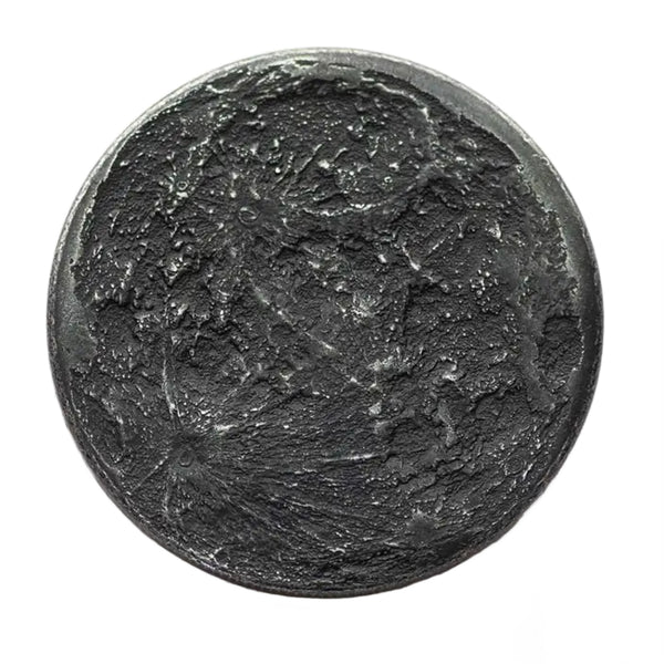 A round black iron coin with a highly detailed, textured lunar surface design featuring craters and shadows, isolated on a white background.