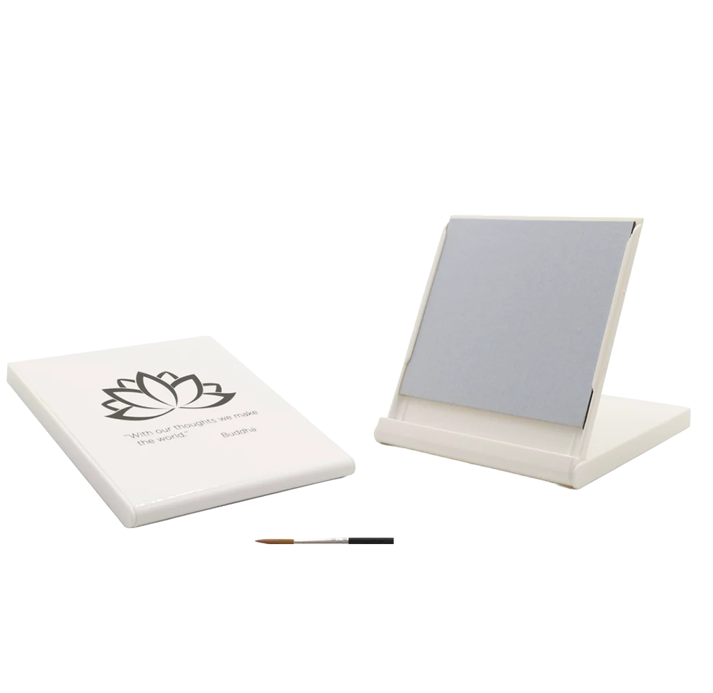 A white rectangular folding water-painting set shown on a plain white background, including the closed lid with a black lotus flower graphic and quote, the open painting board in its stand, and a small paintbrush.