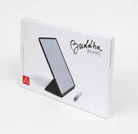 White retail box for the Buddha Board Pro, showing a black-framed board on a stand and a small gray stylus, photographed on a clean white background.