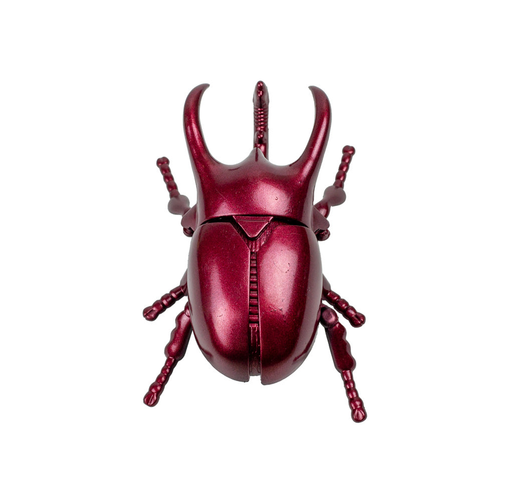 Red metallic beetle-shaped object on a white background