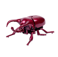 Red metallic beetle-shaped object on a white background