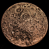 A circular copper-colored metal coin featuring a textured, cratered moon or planetary surface design, shown against a solid black background.