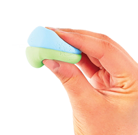 A hand pinches soft blue and green modeling clay against a white background, showing its pliable texture in a bright, clean close-up.