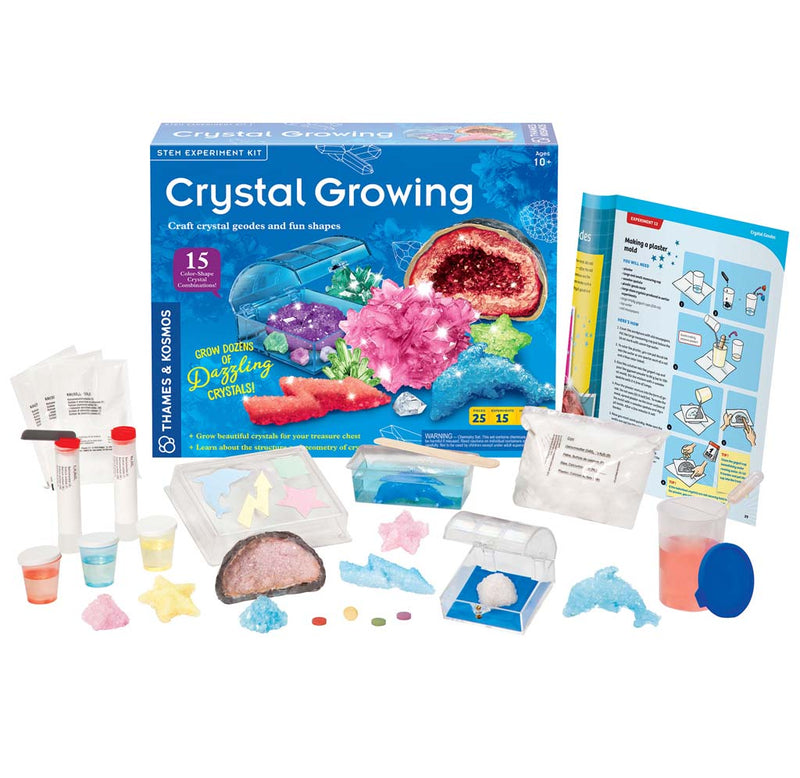 The Crystal Growing Kit comes with molds, chemicals, dyes, and a clear acrylic box for display. These essential components are showcased in front of the product box.