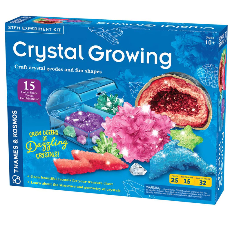 A blue box containing an assortment of crystals, such as a brown geode, pink spikey crystal, red lightning bolt, blue dolphin, and green star, all in various colors. Also there is a blue acrylic box with a green and purple crystal inside.