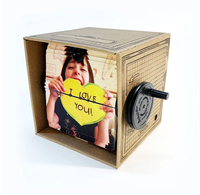 A handmade cardboard fliposcope displays a smiling child holding a yellow heart marked “I love you,” with a black side crank; playful, heartfelt tone.