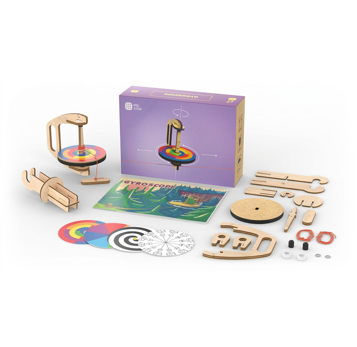 A boxed STEM science kit displays wooden spinning-top parts, colorful discs, printed activity sheets, and small components, suggesting hands-on, playful learning.