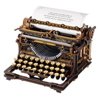 An ornate black-and-gold antique typewriter with round keys and exposed mechanisms displays a sheet of printed lyrics, evoking craftsmanship and nostalgia.