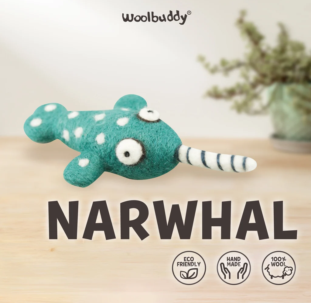 A playful teal felt narwhal with white spots, googly eyes, and a striped tusk sits above bold “NARWHAL” text; eco-friendly, handmade wool badges add a cozy tone.
