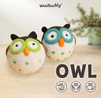 Two handmade wool felt owl ornaments, one with lime-green and one with teal eye patches, sit on a pale wooden surface; eco-friendly, playful decor.