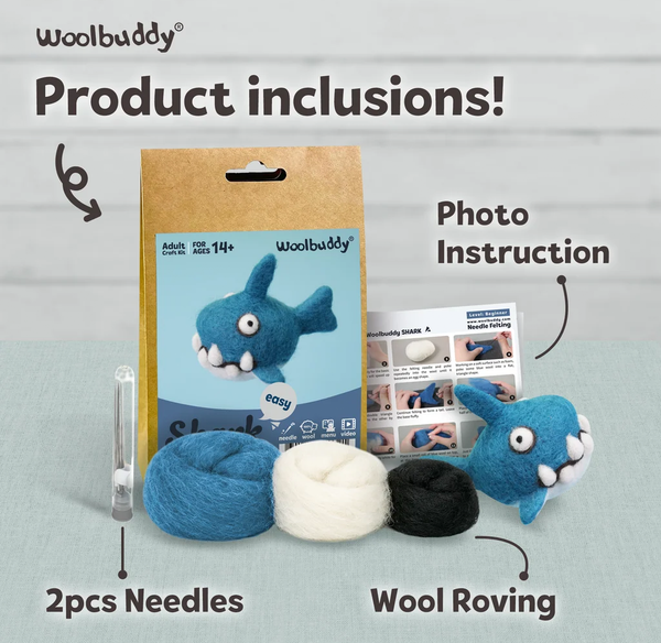 Woolbuddy “Product inclusions” display shows a felted blue shark, photo instruction sheet, two needles, and blue, white, and black wool roving; friendly craft-kit presentation.