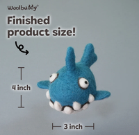 A handmade blue felted monster plush with two upright ears, side fins, googly eyes, and white teeth; labeled finished size: 4 inches tall by 3 inches wide.