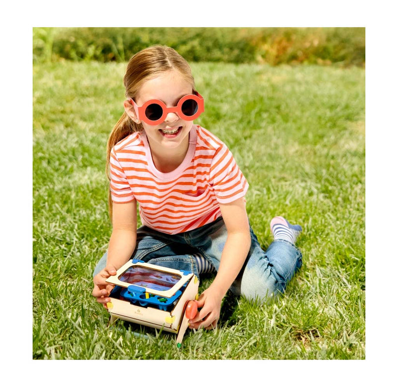 Young child demoing the DIY solar recycler on the grass.