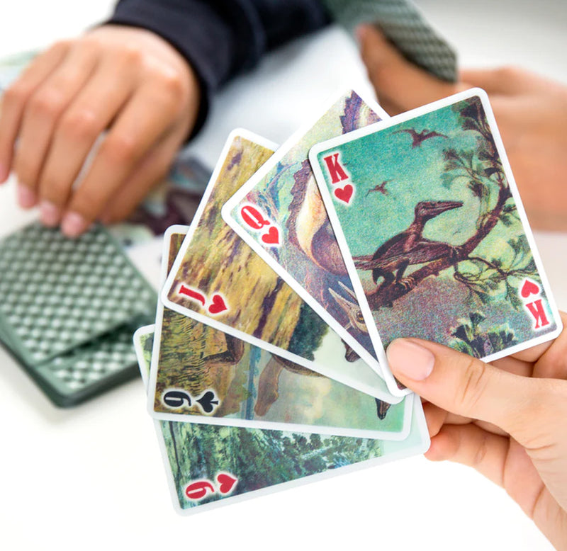 A hand holding five cards: the nine of hearts, nine of spades, jack of hearts, queen of hearts, and king of hearts. Each card has a different design. 