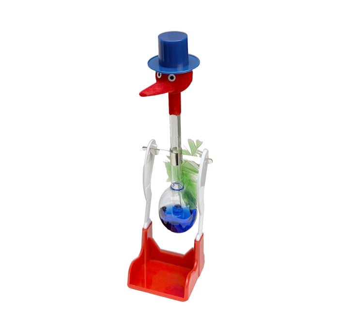 A classic glass novelty drinking bird toy balancing on a white & red pivot stand with a red felt head and beak, a blue top hat and green feathers against a white background.