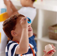 Child playing with toy kaleidoscopes in a home setting