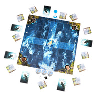 A board game setup photographed from above on a white background, with a large blue icy game board at center surrounded by cards, tokens, dice, and small pieces.
