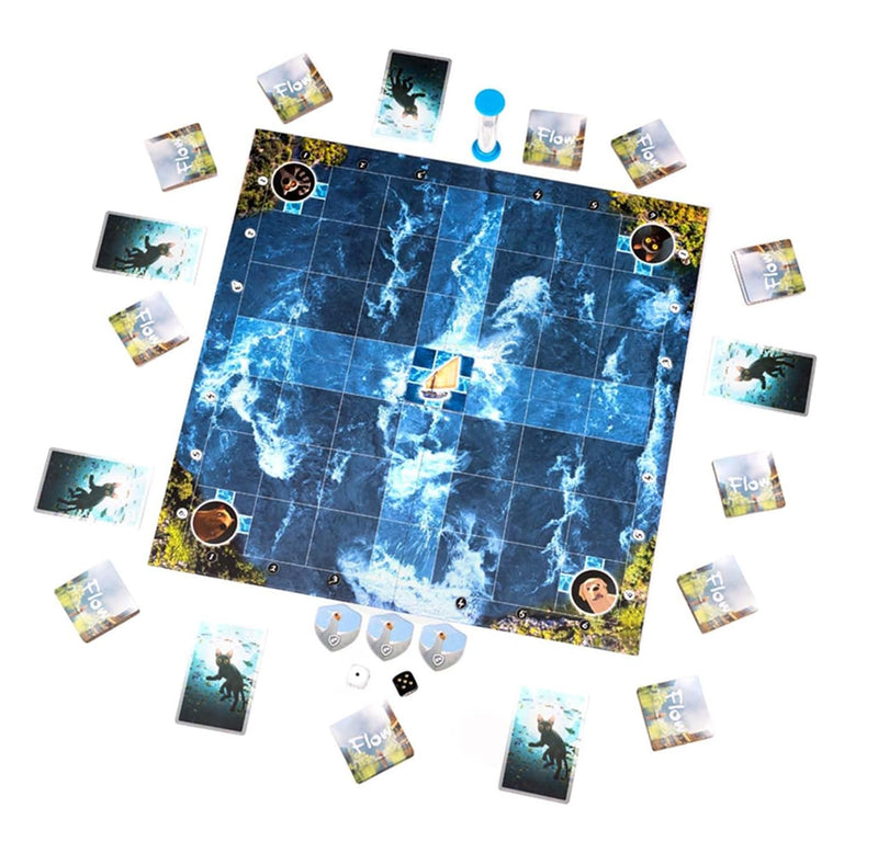 A board game setup photographed from above on a white background, with a large blue icy game board at center surrounded by cards, tokens, dice, and small pieces.