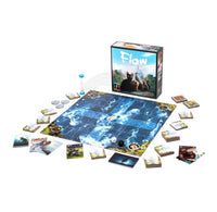 The board game Flow: Water is displayed on a clean white background, including the main game board, the product box, a sand timer, and various player cards and tokens arranged around the board.