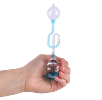 A hand holds a small transparent hand boiler filled with blue liquid, curved tubing, and a floating bulb, suggesting a playful science experiment.