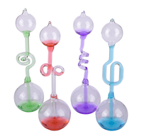 Four colorful glass hand boilers stand against a white background, with clear bulb-shaped chambers and twisted green, red, purple, and blue stems; playful, whimsical tone.