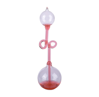 A delicate glass hand boiler with two clear spherical chambers, a slender stem, and looped handles, isolated against white; elegant, vintage feel.