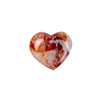 Heart-shaped stone with red and white patterns on a white background