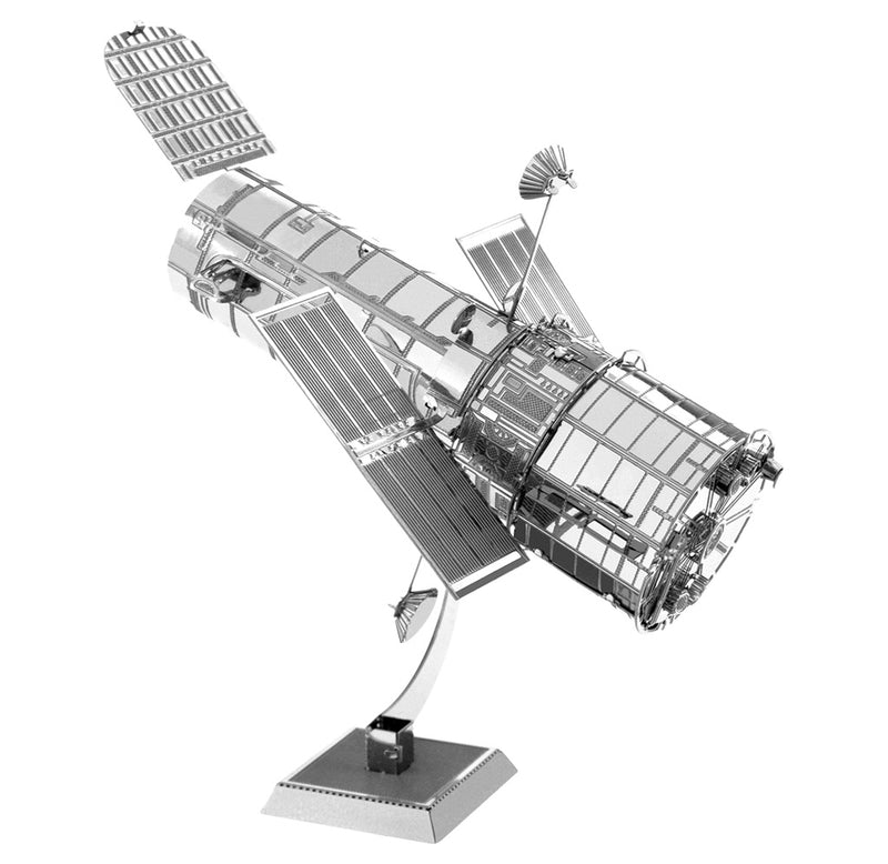 Side view image of the completed model. The entire model is silver with a cylinder body and flat rectangle pieces on either side of the body. The model is suspended above a square base with a curved metal piece. 