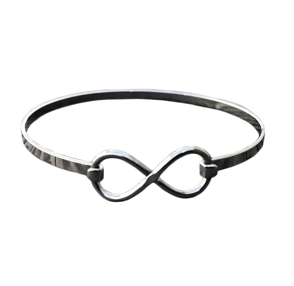 A silver bracelet with an infinity symbol on it.