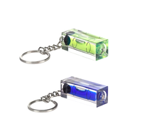 Two miniature keychain bubble levels—one green and one blue—sit on a white background, each attached to a silver chain and split ring, creating a practical, colorful product display.