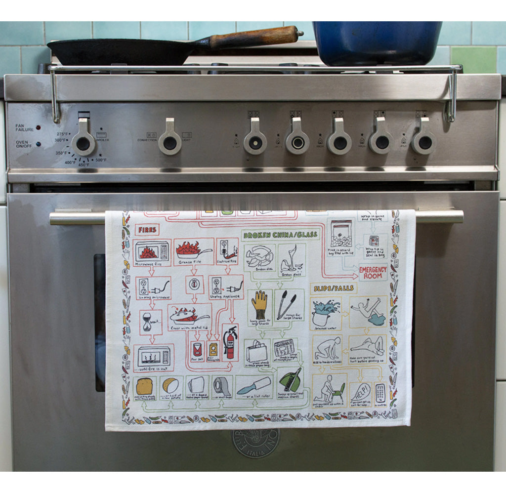 Stainless steel oven with a towel rack holding a towel with illustrations, against a tiled wall.