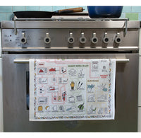 Stainless steel oven with a towel rack holding a towel with illustrations, against a tiled wall.