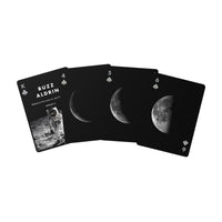 Four black playing cards fanned out on a white background, featuring moon phase imagery and the text 'BUZZ ALDRIN' on the top card.