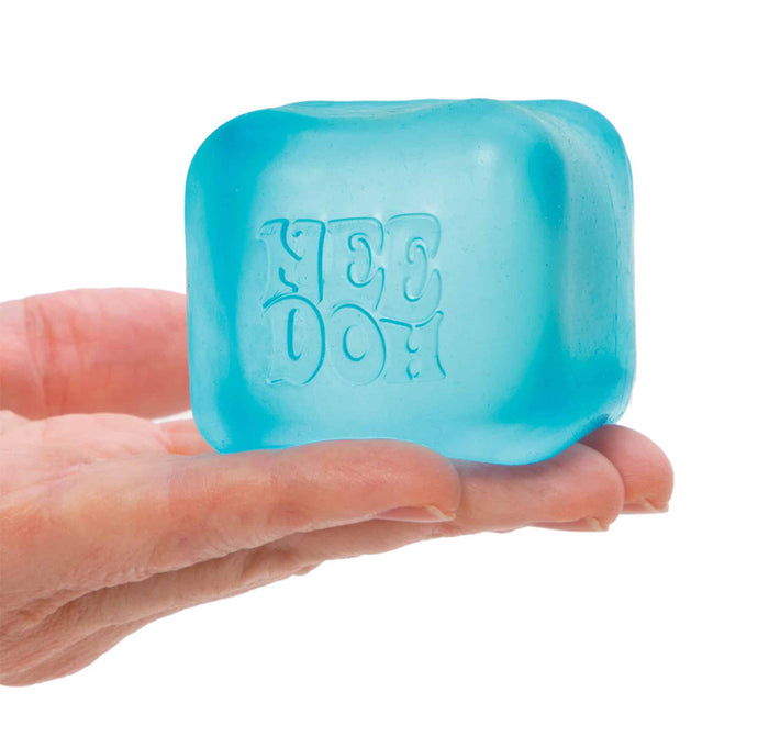 Blue ice cube-shaped product held in a hand against a white background