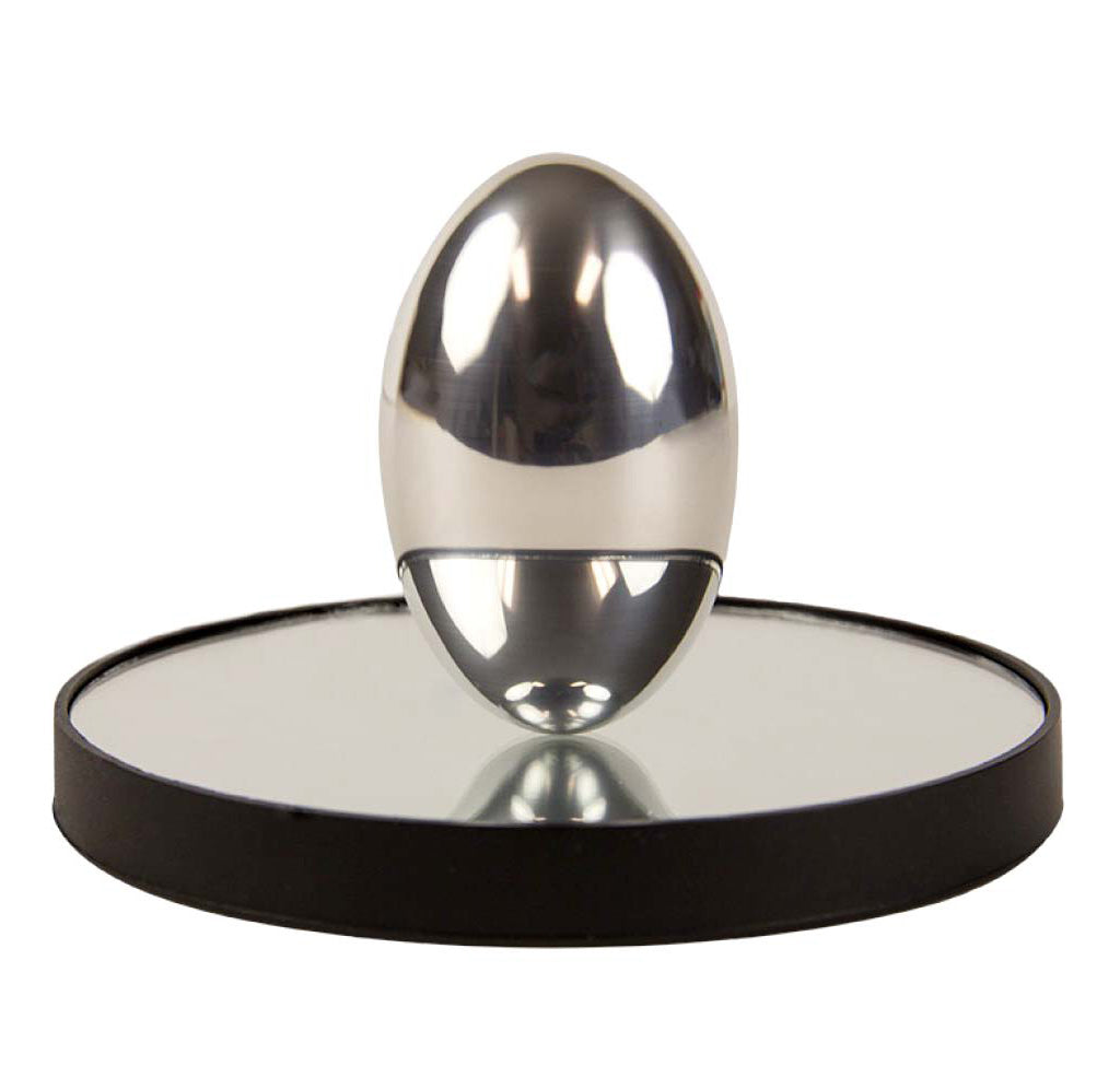 Prolate ellipsoid made out of sold non-magnetic aluminum that, when one spins on its side, will flip upright and continue to spin. It sits upon a flat round mirror encased with a black rim.