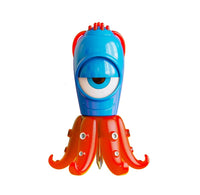 A colorful plastic toy shaped like a one-eyed monster with a blue head, red tentacles, and a small gold blade at the tip, isolated on a white background.