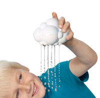 A smiling child in a blue shirt holds a white cloud-shaped toy overhead, releasing thin streams of water like rain; playful, imaginative scene on white.
