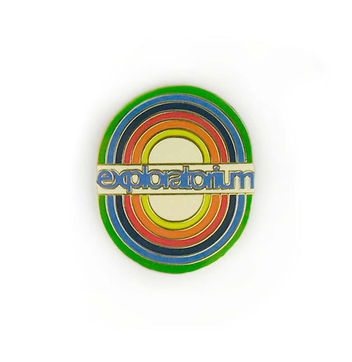 Oval pin with rainbow circles. The word "exploratorium" in blue on a white rectangle is in the middle of the pin.